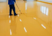 garage floor painting process with roller applying epoxy floor paint to concrete