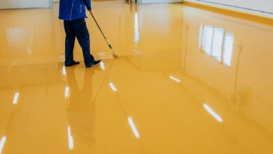 garage floor painting process with roller applying epoxy floor paint to concrete