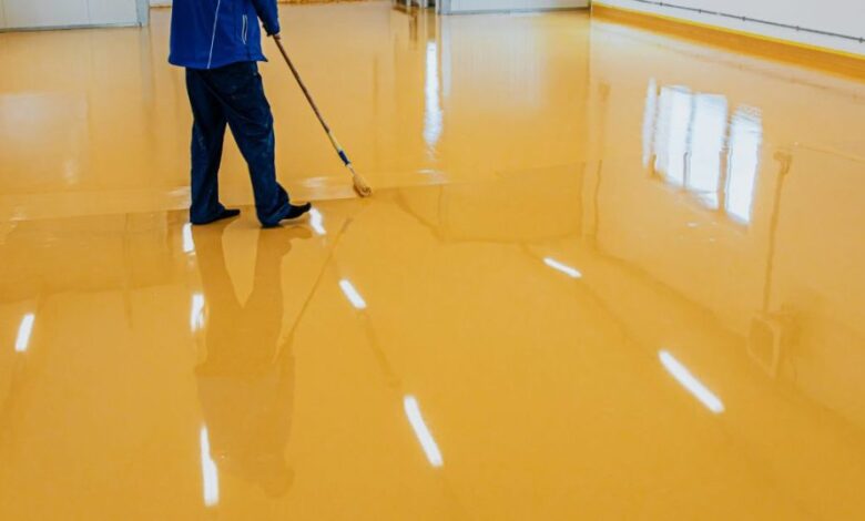 garage floor painting process with roller applying epoxy floor paint to concrete