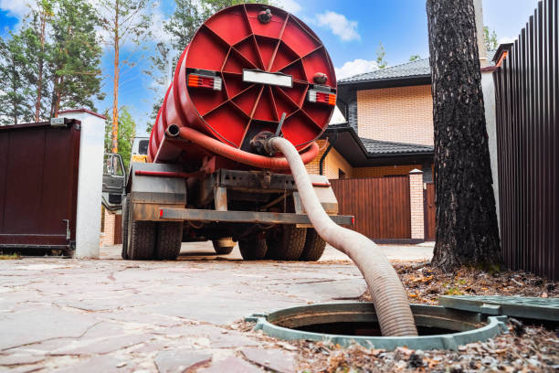 Septic tank pumping services being performed with a vacuum truck
